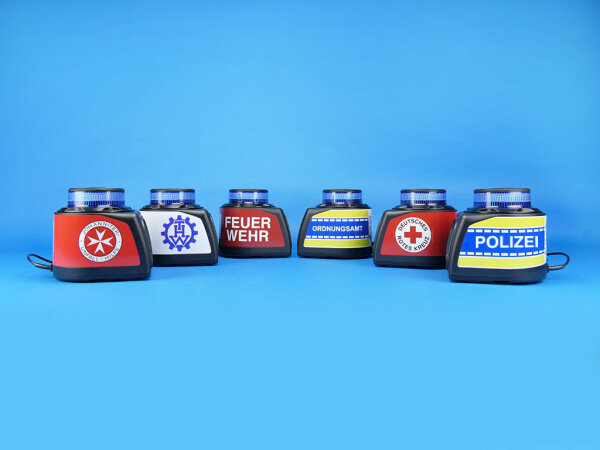 Mobile Warnanlagen MoWa 2, jeweils mit verschiedenen Beschriftungen/Logos: Johanniter-Unfall-Hilfe, THW, Feuerwehr, Ordnungsamt, Deutsches Rotes Kreuz und Polizei, auf blauem Hintergrund