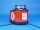 Mobile Warnanlage mit blauer Kennleuchte und roter Beklebung, darauf ist das Logo des Deutschen Roten Kreuzes abgebildet, Ansicht schräg von hinten